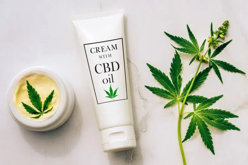 a CBD cream bottle and a CBD container with a plant on it