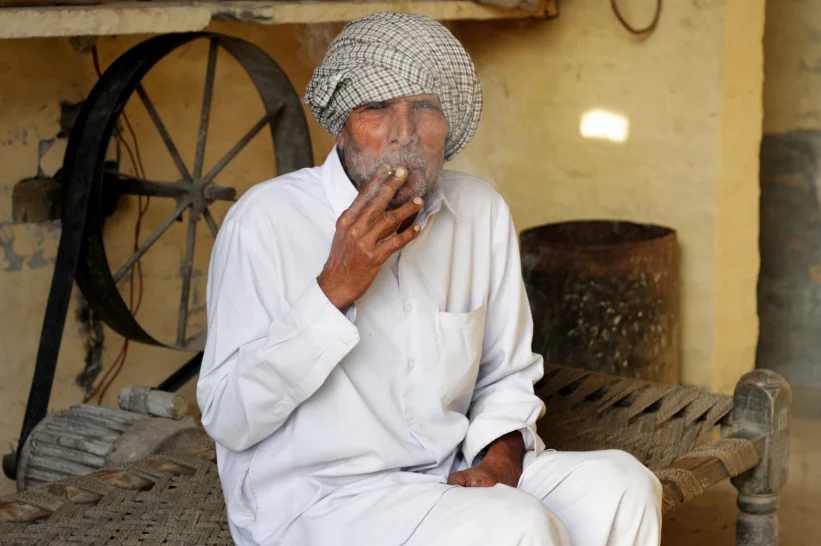a man in India smoking rolled hash