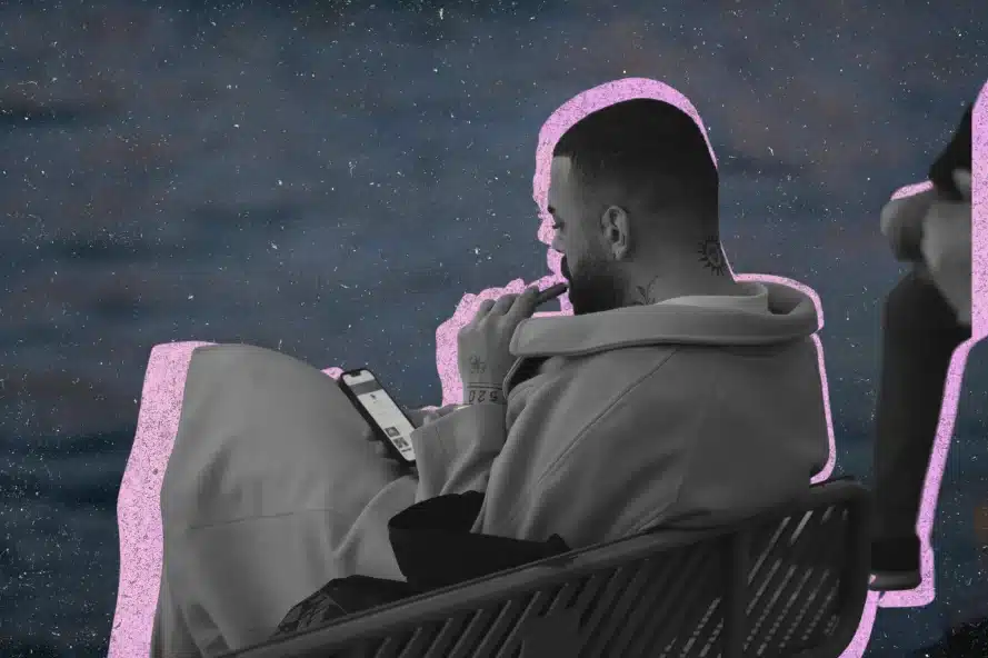A person calmly vaping while sitting by the water.