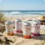 Four colorful seltzer cans on beach