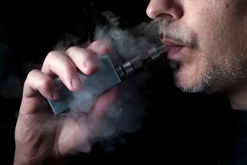 Person vaping with smoke exhaled