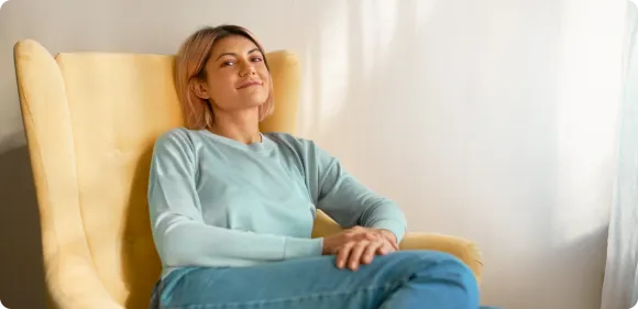 Woman relaxing in a yellow armchair