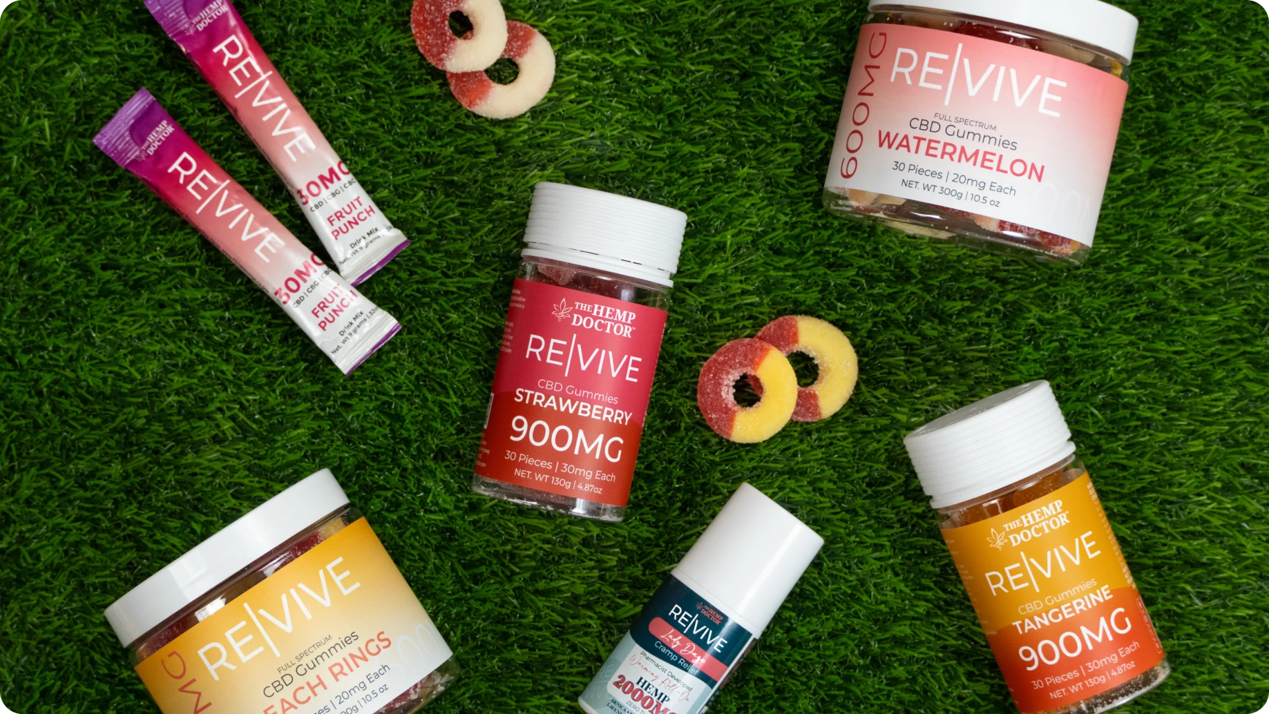 RE|VIVE CBD gummies, tinctures and gummy sticks laid out on grass