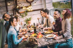 Young People Dining And Having Fun Drinking Red Wine Together.