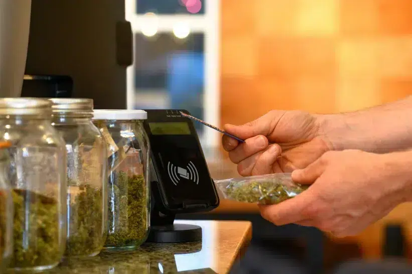 a person paying with a credit card at a dispensary counter