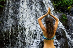 A woman doing yoga at a waterfall in Clemson, SC. CBD Oil in Clemson, SC