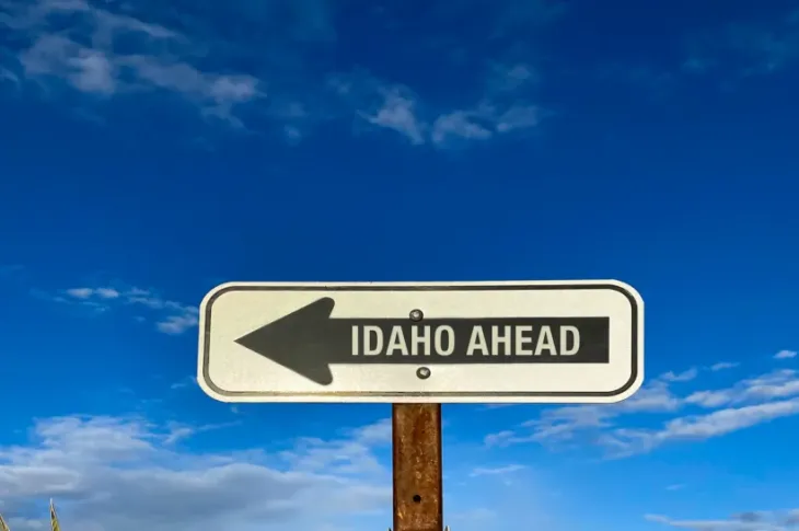 a sign with an arrow pointing to the right reading Idaho Ahead