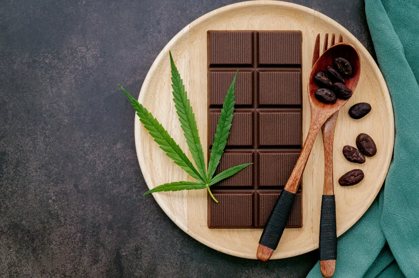 a plate with a fork and spoon, weed, and chocolate bar.