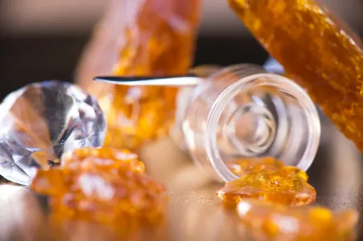 a close up of a THCA concentrate alongside a diamond