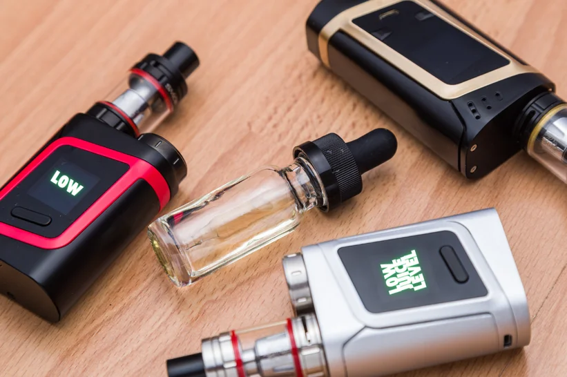 a group of vaping devices on a table with their digital screens saying low juice level